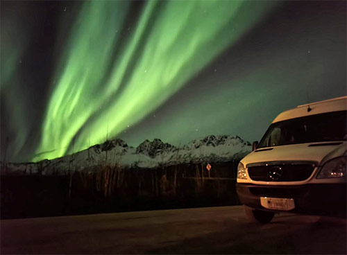 Van rental driving beneath beautiful Alaska Northern Lights